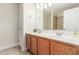 Well-lit bathroom featuring double sinks, wooden cabinets, and tile flooring at 445 W Gary Ave, Gilbert, AZ 85233