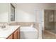 Well-lit bathroom featuring a separate tub, tiled shower, and vanity for a spa-like experience at 445 W Gary Ave, Gilbert, AZ 85233