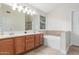Bathroom with double sinks, a bathtub, and tiled walls for a luxurious and functional space at 445 W Gary Ave, Gilbert, AZ 85233