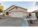 Tan home featuring a two-car garage, neutral trim, and a concrete driveway at 445 W Gary Ave, Gilbert, AZ 85233