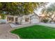 Charming tan home featuring a two-car garage, green grass and neutral trim at 445 W Gary Ave, Gilbert, AZ 85233