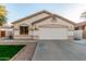 Home featuring a two-car garage, manicured lawn, and desert landscaping at 445 W Gary Ave, Gilbert, AZ 85233