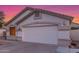 Home featuring a two-car garage, manicured lawn, and desert landscaping at 445 W Gary Ave, Gilbert, AZ 85233