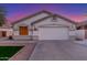Home featuring a two-car garage, manicured lawn, and desert landscaping at 445 W Gary Ave, Gilbert, AZ 85233