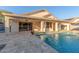 Home's backyard pool features travertine tile, landscaping, and a covered patio at 445 W Gary Ave, Gilbert, AZ 85233