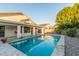 Inviting pool surrounded by travertine tile and artificial turf at 445 W Gary Ave, Gilbert, AZ 85233