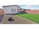 Spacious backyard featuring artificial grass, desert landscaping, and a brick perimeter at 45734 W Sky Ln, Maricopa, AZ 85139
