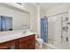 Bright bathroom featuring a walk-in shower, spacious vanity, and neutral tile flooring at 45734 W Sky Ln, Maricopa, AZ 85139