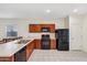 Well-lit kitchen featuring wooden cabinets, black appliances, and a tiled floor at 45734 W Sky Ln, Maricopa, AZ 85139