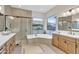 Bright bathroom featuring a large soaking tub, a glass enclosed shower, and double vanity sinks at 500 E Watermelon Ln, Queen Creek, AZ 85140