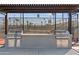 Outdoor grilling station with two stainless steel grills, counter space, and storage beneath a shaded pergola at 7807 E Main St # Cc-85, Mesa, AZ 85207