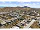 Aerial view shows the property's position in a neighborhood with mature desert landscaping and views of the mountains at 8117 E Sweet Bush Ln, Gold Canyon, AZ 85118