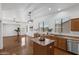 Open kitchen with an island, stainless steel appliances, custom cabinetry, and hardwood floors at 8117 E Sweet Bush Ln, Gold Canyon, AZ 85118