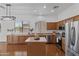 Well-lit kitchen featuring custom cabinets, an island, stainless steel appliances, and laminate countertops at 8117 E Sweet Bush Ln, Gold Canyon, AZ 85118