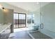 Modern bathroom with a glass shower, a soaking tub and large windows offering backyard views at 8510 S 9Th Dr # 20, Phoenix, AZ 85041