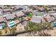 A high angle aerial shot shows fenced yards, desert landscaping, neighborhood streets, and swimming pools at 8554 W Keim Dr, Glendale, AZ 85305