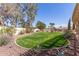 Spacious backyard with a well-manicured lawn, desert landscaping, and mature trees, ideal for outdoor living at 8554 W Keim Dr, Glendale, AZ 85305