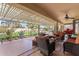 Relaxing covered patio with comfortable seating, offering views of the lush backyard and mature landscaping at 8554 W Keim Dr, Glendale, AZ 85305