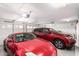 Spacious two car garage showing two red vehicles and automated door at 8554 W Keim Dr, Glendale, AZ 85305