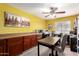 Spacious office boasts built-in cabinets, a large desk, and a ceiling fan for added comfort at 8554 W Keim Dr, Glendale, AZ 85305