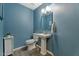 Powder room features a blue paint, mirror, and pedestal sink with updated faucet at 8813 S 51St St # 3, Phoenix, AZ 85044