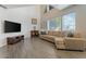 Bright living room featuring wood floors, large windows, and a comfortable tan sectional couch at 8813 S 51St St # 3, Phoenix, AZ 85044