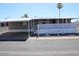 Manufactured home with covered parking, steps and a decorative lattice front and palms in view at 9501 E Broadway Rd # 237, Mesa, AZ 85208