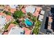 A top-down aerial captures a vibrant pool area nestled within tropical palm trees and community buildings at 10410 N Cave Creek Rd # 2034, Phoenix, AZ 85020