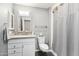 Cozy bathroom with granite counters, white cabinets, and a shower with gray curtain at 10533 W Granada Dr, Sun City, AZ 85373