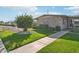 Landscaped front yard with green lawn, mature trees and a sidewalk leading to the house at 10533 W Granada Dr, Sun City, AZ 85373