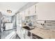 Bright kitchen showcasing white cabinets, granite countertops, and a stainless steel sink at 10533 W Granada Dr, Sun City, AZ 85373