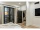 Bedroom with black French doors leading to a porch, and a peek into another room at 11268 E Moonlight Cyn, Scottsdale, AZ 85255