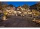 Stately exterior of luxury home with arched entry and manicured grounds at twilight at 11268 E Moonlight Cyn, Scottsdale, AZ 85255