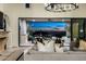 Cozy living room extends to a patio with city and mountain vistas, complemented by modern lighting and neutral decor at 11268 E Moonlight Cyn, Scottsdale, AZ 85255