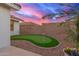 Beautiful backyard featuring a putting green, desert landscaping, and a vibrant sky at 11430 E Neville Ave, Mesa, AZ 85209