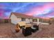 Backyard features desert landscaping, patio and outdoor furniture with sunset sky at 11430 E Neville Ave, Mesa, AZ 85209