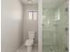 Bathroom with a toilet next to the marble tiled shower with glass door and a small window at 11430 E Neville Ave, Mesa, AZ 85209