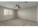 Spacious carpeted bedroom with neutral colors, ceiling fan, and bright window with shutters at 11430 E Neville Ave, Mesa, AZ 85209