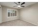 Carpeted bedroom featuring neutral colors, ceiling fan, and a bright window with shutters at 11430 E Neville Ave, Mesa, AZ 85209