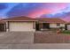 Charming single-story home with a tile roof, desert landscaping, and an attached two-car garage at dusk at 11430 E Neville Ave, Mesa, AZ 85209