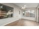 Bright sun room with brick accent wall, wood-style floors, windows, and a ceiling fan at 11430 E Neville Ave, Mesa, AZ 85209