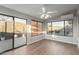 Bright sun room with wood-style floors, windows, sliding glass door, and a ceiling fan at 11430 E Neville Ave, Mesa, AZ 85209