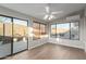 Bright sun room with wood-style floors, windows, sliding glass door, and a ceiling fan at 11430 E Neville Ave, Mesa, AZ 85209