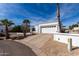 Single-story home featuring a two-car garage and desert landscaping for low maintenance at 1202 E Winged Foot Rd, Phoenix, AZ 85022