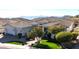 Wide shot of a single-story home with a large driveway, tile roof, well-maintained lawn, and mountain backdrop at 122 E Desert Wind Dr, Phoenix, AZ 85048