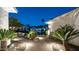 Charming front entrance with illuminated walkway, lush greenery, and a cozy seating area at 122 E Desert Wind Dr, Phoenix, AZ 85048