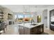 Modern kitchen island with stone fireplace, stainless steel appliances, and open view of the backyard at 122 E Desert Wind Dr, Phoenix, AZ 85048