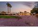 Expansive backyard at dusk features desert landscaping, gravel areas, green lawn and a covered patio with desert sunsets at 12222 S Appaloosa Dr, Phoenix, AZ 85044