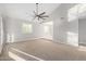 Primary bedroom showcasing carpet floors, ceiling fan, and large windows providing ample natural light at 12222 S Appaloosa Dr, Phoenix, AZ 85044