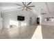 Living room features tile floors, vaulted ceilings with fan, clerestory window, and mounted TV at 12222 S Appaloosa Dr, Phoenix, AZ 85044